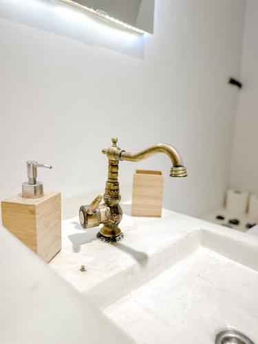a bathroom sink with a brass faucet on a counter at Mountain Bliss Guesthouse 2 next to Sougia in Agrilés