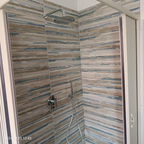 a shower with a wooden wall at Villa Mariana Bed and Breakfast in Saluzzo