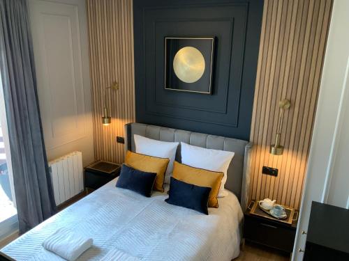 Un dormitorio con una cama con almohadas azules y amarillas. en L ecrin Villersois terrasse vue mer, en Villers-sur-Mer