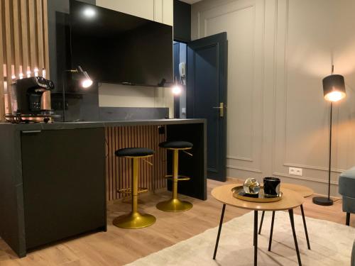 - une cuisine avec deux tabourets de bar et une table dans l'établissement L ecrin Villersois terrasse vue mer, à Villers-sur-Mer