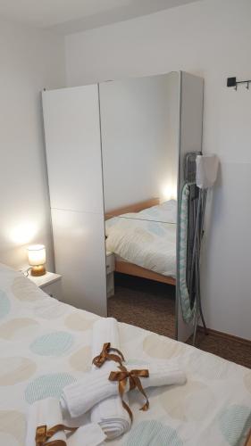 庫蒂納的住宿－Apartman Moslavina，一间带镜子的卧室和一张带毛巾的床