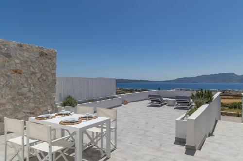 a patio with a white table and chairs and the ocean at CASA ANNA LOFT Boutique House with Full Sea View in Adamantas