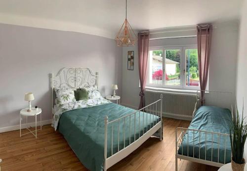 un dormitorio con una cama y una ventana en Gîte de la Costelle, en Fraize