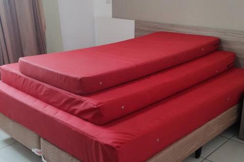 three red cushions sitting on top of a bed at Apartamento Privê Riviera 10 in Caldas Novas