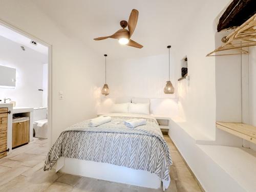 a white bedroom with a bed and a ceiling fan at Mountain Bliss Guesthouse 2 next to Sougia in Agrilés