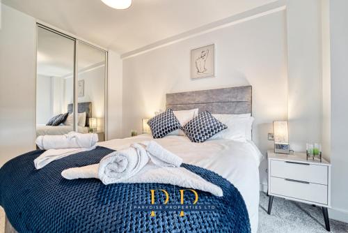 1 dormitorio con 1 cama grande y toallas. en The Middlewood Plaza Suite - By Parydise Properties - Business or Leisure stays, Central Location, Sleeps 4, Salford, en Mánchester