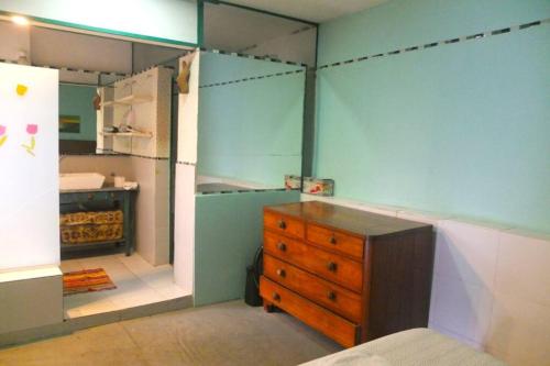 a bedroom with a wooden dresser and a refrigerator at CasaSanTelmo 2984 in Buenos Aires
