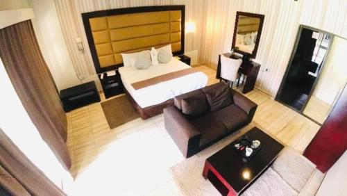 pokój hotelowy z łóżkiem i kanapą w obiekcie Makgovango Hotel w mieście Gumare
