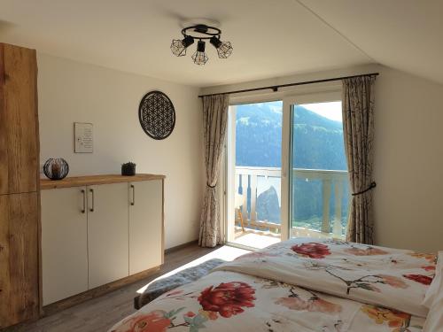 1 dormitorio con cama y ventana grande en Panoramahof Bianca, en Winklern