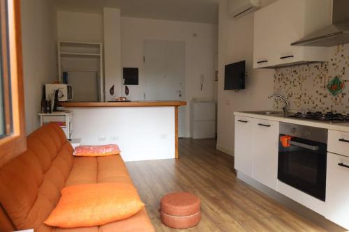 een woonkamer met een bank en een keuken bij Jitaku MERAKI in Cagliari