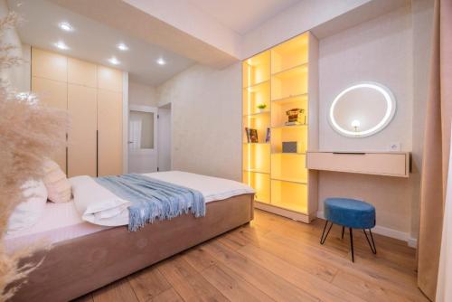 1 dormitorio con cama, espejo y silla en Стильная квартира в центре города, en Almaty