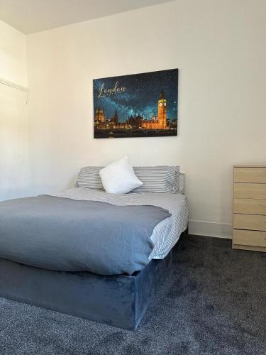 a bedroom with a bed with a painting on the wall at King House in Carlisle