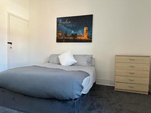 a bedroom with a bed and a painting on the wall at King House in Carlisle