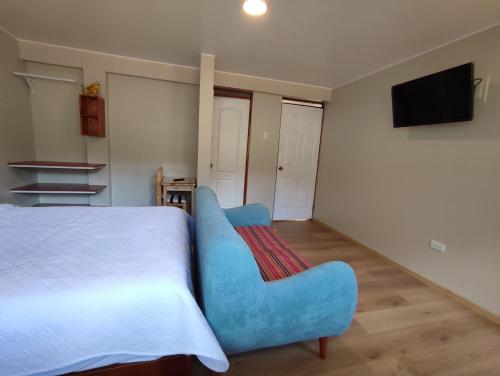- une chambre avec un lit et un canapé bleu dans l'établissement Casa Alojamiento Tocllaraju, à Tarica