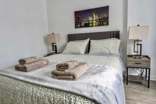 a bedroom with a bed with towels on it at Modern Condo 2BR 4 beds AC Wi-Fi Free Parking in Laval