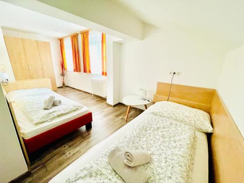 a bedroom with two beds and a table and a window at Villa Maria Theresia - contactless Self-Check-IN in Bad Goisern