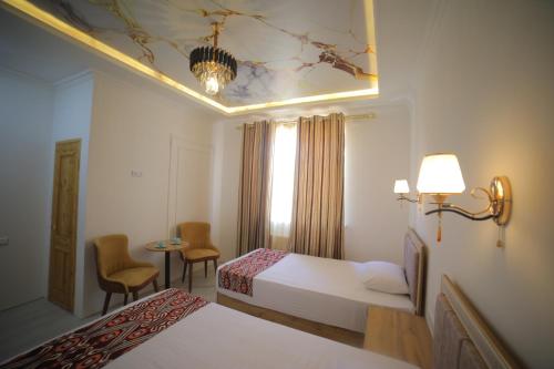 Cette chambre comprend 2 lits et une fenêtre. dans l'établissement Annex Hotel, à Khiva