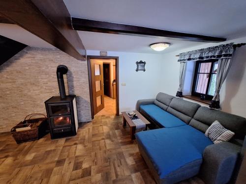 a living room with a couch and a wood stove at Chalupa U Křížku Říčky v Orlických horách in Říčky