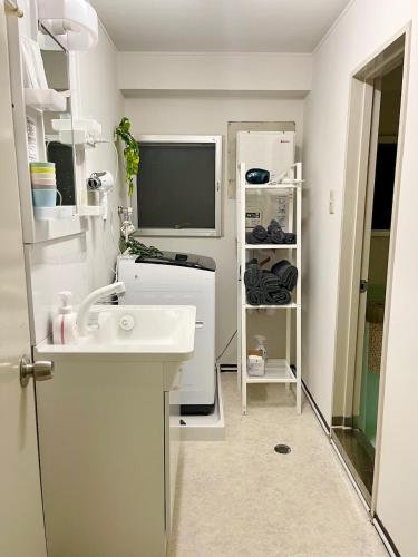 a small bathroom with a sink and a mirror at 湘南中心部　江ノ島・鎌倉・箱根　平塚駅5分　和室洋室最大6人 新宿駅から1時間パーティー禁止 in Shinjuku