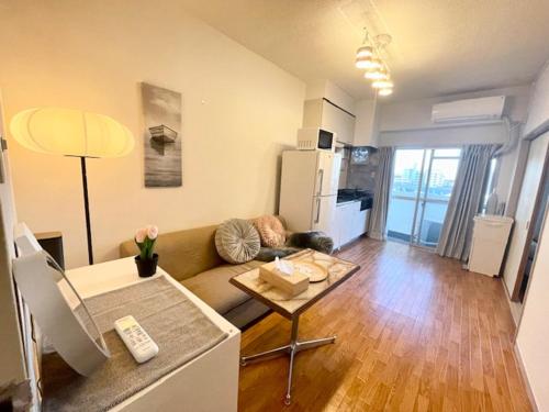 a living room with a couch and a table at 湘南中心部　江ノ島・鎌倉・箱根　平塚駅5分　和室洋室最大6人 新宿駅から1時間パーティー禁止 in Shinjuku