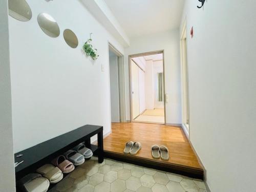 a living room with a row of shoes on the floor at 湘南中心部　江ノ島・鎌倉・箱根　平塚駅5分　和室洋室最大6人 新宿駅から1時間パーティー禁止 in Shinjuku