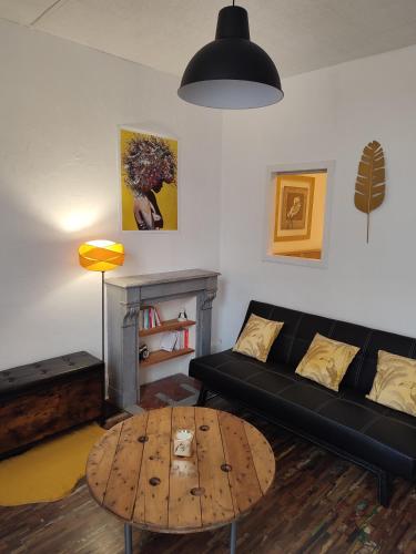 sala de estar con sofá negro y mesa en T1 lumineux et climatisé, en Chagny
