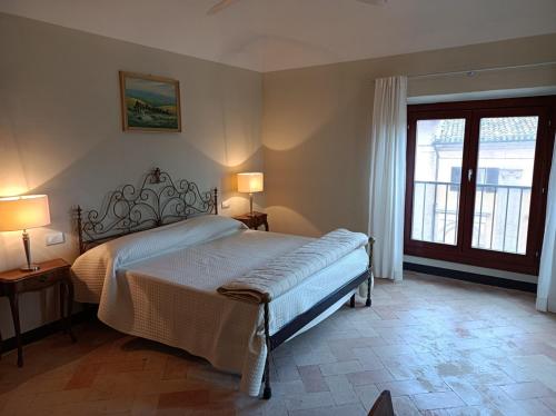 - une chambre avec un lit, deux lampes et une fenêtre dans l'établissement Crivelli-Penthouse, à San Severino Marche