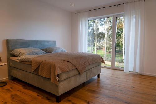 ein Schlafzimmer mit einem Bett und einem großen Fenster in der Unterkunft Luxuriöse Penthousewohnung mit Fernblick und vielen Wanderwegen in Melsbach