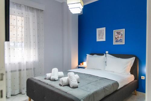 1 dormitorio azul con 1 cama grande con almohadas blancas en 50 DANAIDES, en Argos