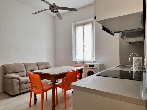 een keuken met een tafel en stoelen en een bank bij Nuovissimo appartamento a Marina di Grosseto in Marina di Grosseto