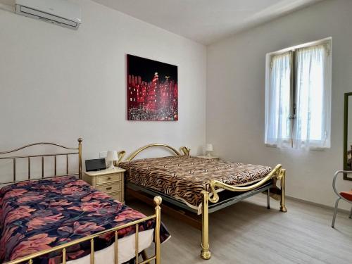 een slaapkamer met 2 bedden en een raam bij Nuovissimo appartamento a Marina di Grosseto in Marina di Grosseto