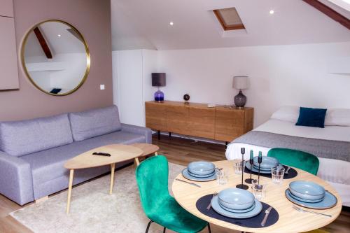 Una sala de estar con una cama, una mesa y sillas. en Le Paisible Choisy-le-Roi - Wifi, Parking Gratuit, RER C à Proximité, en Choisy-le-Roi