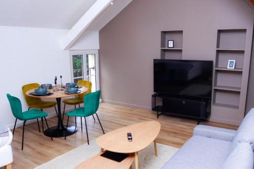 un salon avec une table et une télévision dans l'établissement Le Paisible Choisy-le-Roi - Wifi, Parking Gratuit, RER C à Proximité, à Choisy-le-Roi