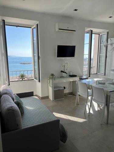 - un salon avec un canapé et une table offrant une vue sur l'océan dans l'établissement Studio magnifique vue mer, à Menton