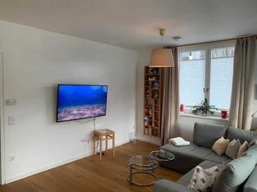 a living room with a couch and a tv on a wall at Apartement stilvoll und großzügig in Windischgarsten