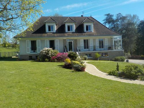 a large white house with a grass yard at CHARMANT APPARTEMENT DANS MAISON DE CARACTERE in Saint-Brice-sur-Vienne
