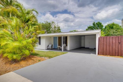 a white garage with a fence and a palm tree at Vero Beach Vacation Rental about 3 Mi to the Ocean! in Vero Beach