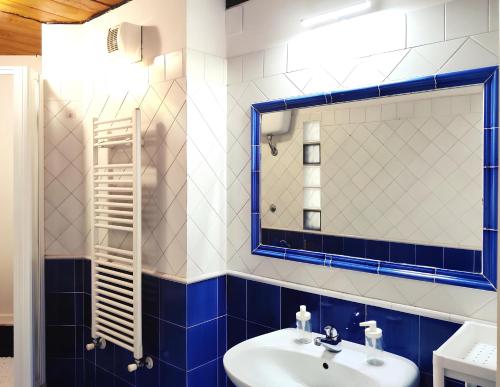 a blue and white bathroom with a sink and a mirror at Maison Le Panche - Careggi in Florence