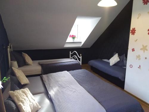 a attic bedroom with two beds and a window at Pension Breidbach in Ensch