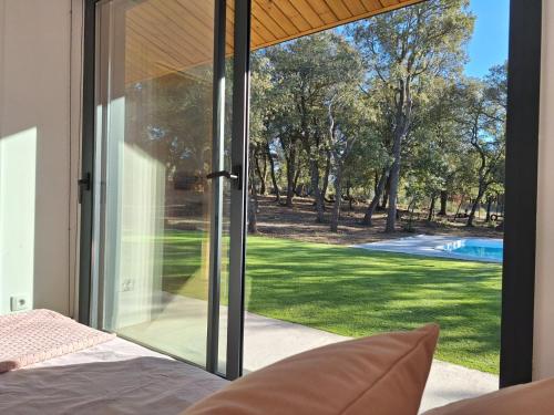 a bedroom with sliding glass doors looking out at a yard at Casa Natura Montseny in El Brull