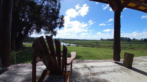 una silla sentada en un porche con vistas a un campo en Casas del lago, en Pan de Azúcar