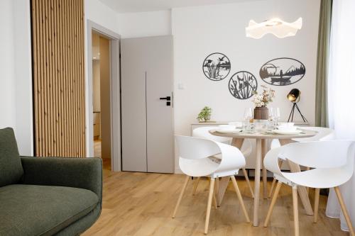a living room with a dining room table and white chairs at The Ground Floor - Apartament Centrum Augustów in Augustów