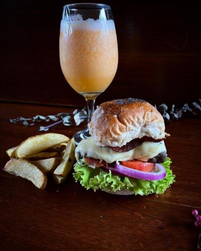 a sandwich and a glass of orange juice and a drink at VoyAca Hotel - Alfareria in Villa de Leyva