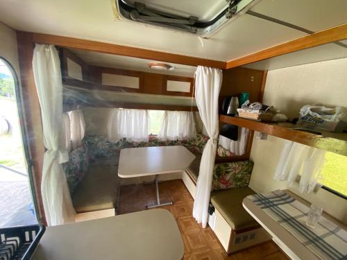 an interior view of an rv with a table and a window at Trailer em Sítio in Timbó