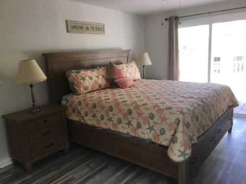 a bedroom with a bed and a lamp and a window at Surfside Beach/ Capt. Jacks ~50 FT From Beach 3br/3ba in Myrtle Beach