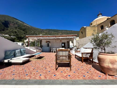 eine Terrasse mit Stühlen, einem Sofa und einem Tisch in der Unterkunft ANTICA DIMORA Santa Marina Salina in Santa Marina Salina