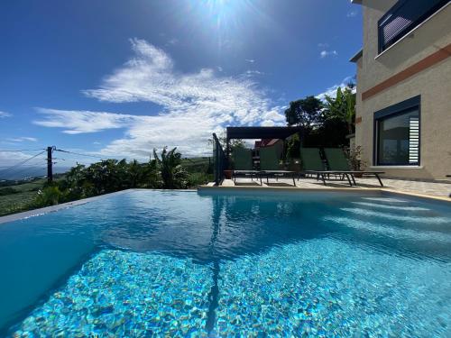 a swimming pool in front of a house at La Villa Des Oliviers in Petite Île