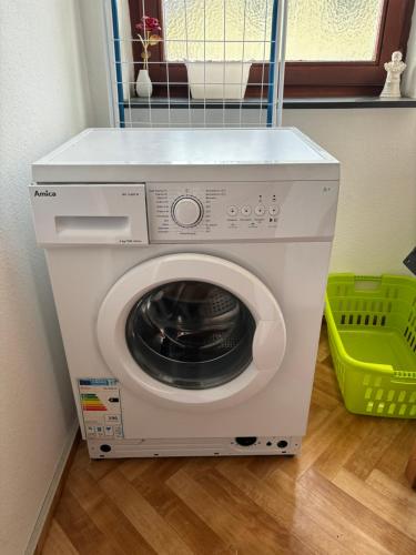 a white washing machine in a room with a green basket at Henriette in Walkenried