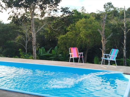 zwei Stühle neben einem Pool in der Unterkunft Rancho yaci in Alexânia