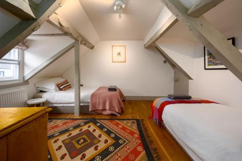 利明頓的住宿－The perfect New Forest / coastal base. Sleeps 9.，阁楼卧室配有两张床和地毯。